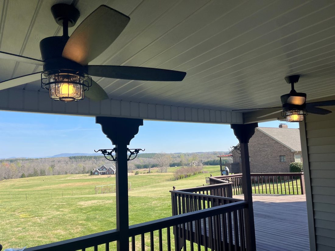 Outdoor ceiling fans with lights installed on a covered porch